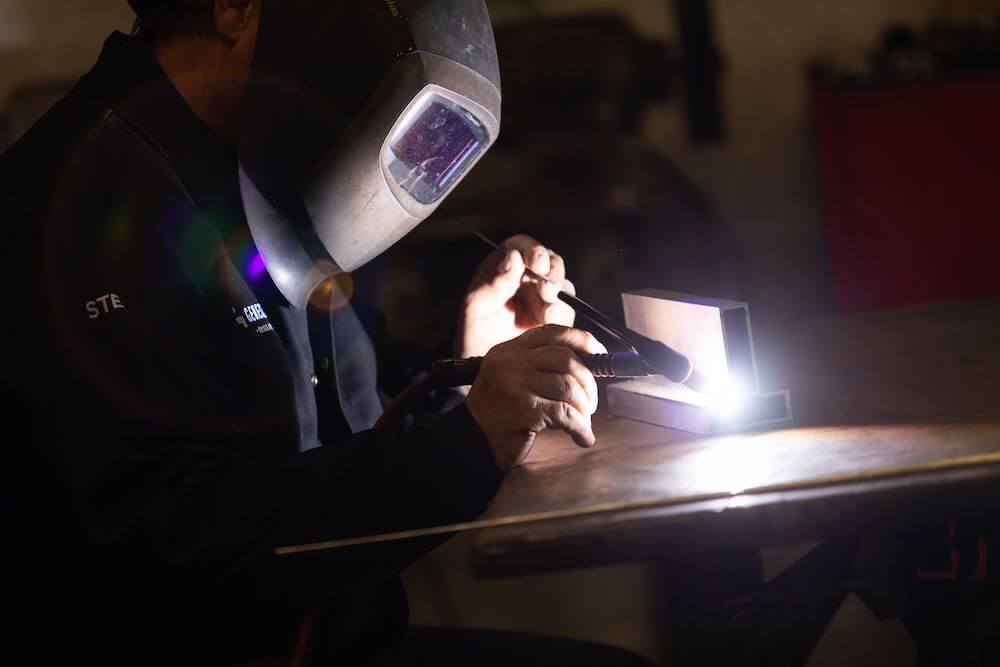 Image shows man working on custom welding project.